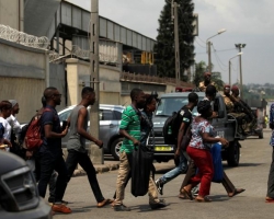 People run as they leave the port of Abidjan after hearing gunfire in Abidjan