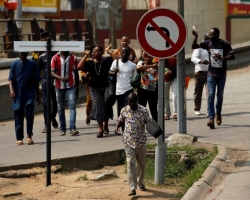 People run as they leave the port of Abidjan after they heard gunfire, in Abidjan